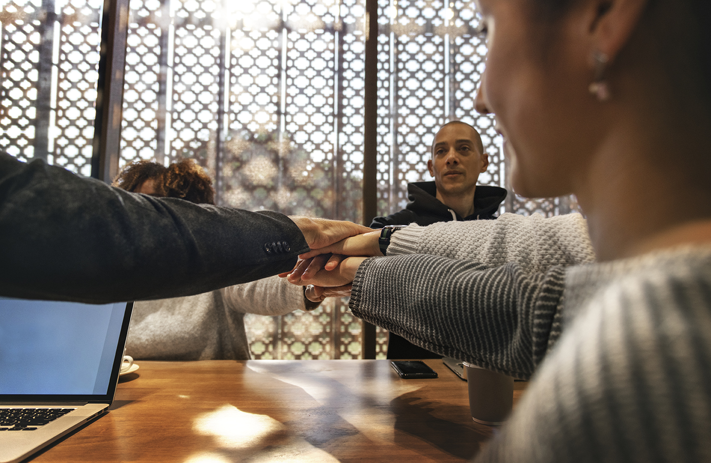Diverse people stacking hands together